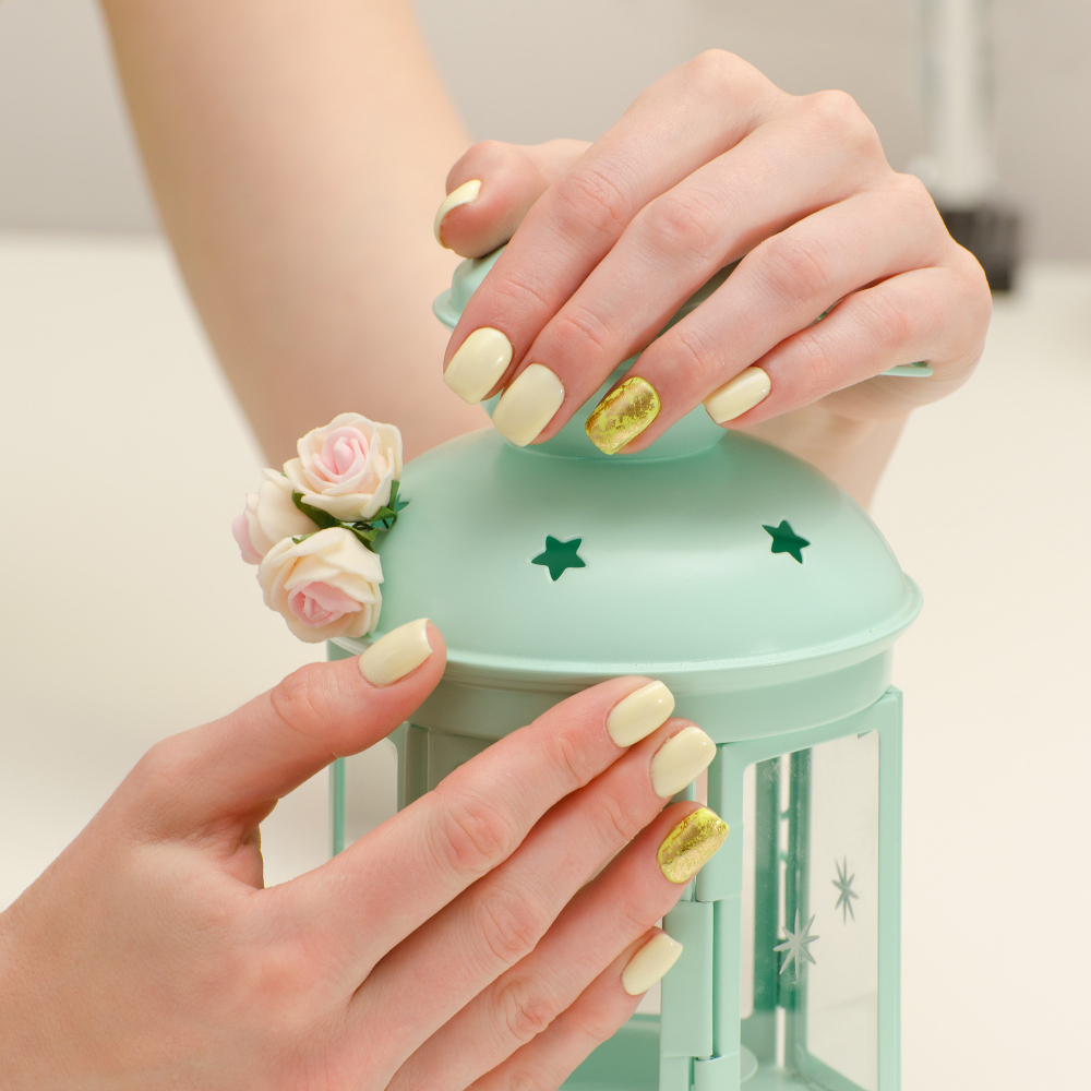 beautiful-female-hands-with-manicure-lamp-candlestick-light-background-yellow-with-gold-nails (1)