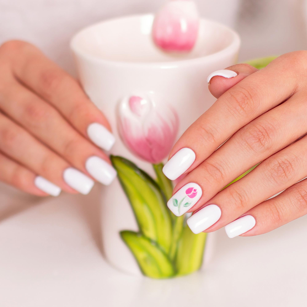 female-hands-with-spring-manicure-nails-near-tea-cup-with-tulips-design
